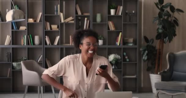 Kobieta trzyma smartfona czytać wiadomości ze świetnymi wiadomościami czuje się uradowany — Wideo stockowe