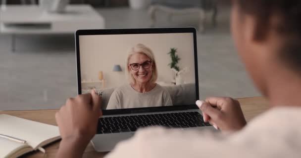 50 's vrouw praten met Afrikaanse collega met behulp van videoconferentie op laptop — Stockvideo