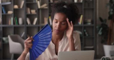 Ofiste sıcaktan ölen bir kadın vantilatör sallıyor, rahatsızlık veriyor.