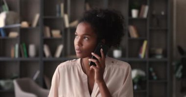 Akıllı telefon tutan Afrikalı genç bir kadın hoparlörden sesli mesaj bırakıyor.