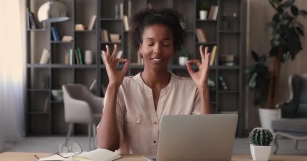 Heitere Afrikanerin baut Stress am Arbeitsplatz ab und übt Meditation — Stockvideo