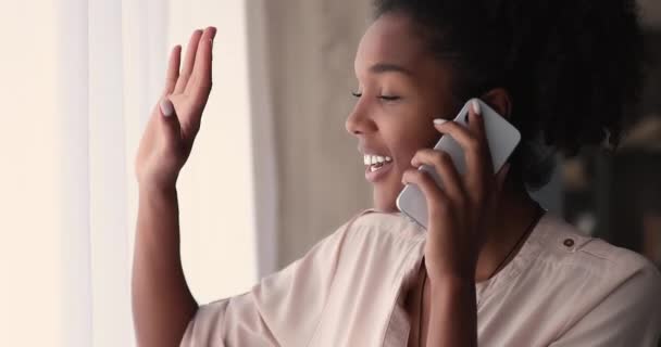 Afričanky pozdravuje přítele z domova, zatímco mluvit na telefonu — Stock video
