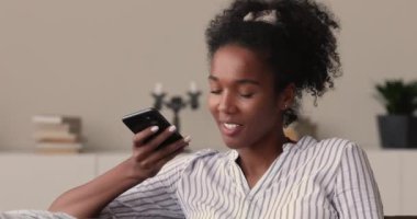 Karışık ırk kadını elinde akıllı telefon ile arkadaşıyla hoparlörden konuşuyor.