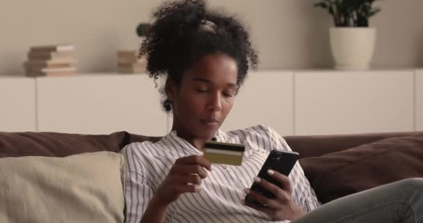 Afrikaanse vrouw met smartphone en creditcard kopen op internet — Stockvideo