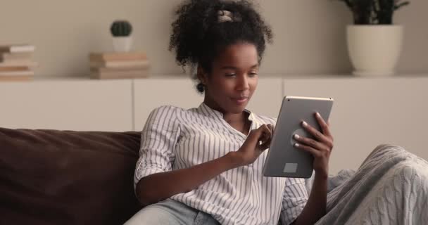 Afrikaanse vrouw lees geweldig nieuws online op tablet voelt gelukkig — Stockvideo