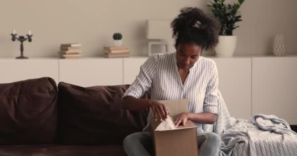 Αφρικανή γυναίκα ανοίγει πολυαναμενόμενο κουτί δεμάτων αισθάνεται ευτυχισμένη — Αρχείο Βίντεο