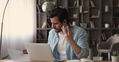 İş yerinde oturan bir işadamı hoparlörden konuşuyor.