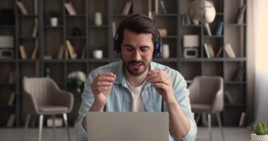 Bilgisayarı ve video çağrı uygulamasını kullanan bir adam istemciyle konuşuyor