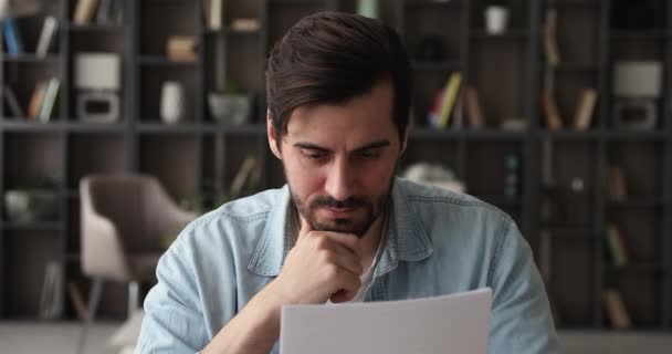 İşyeri masasında oturan konsantre erkek girişimci okuma belgesi — Stok video