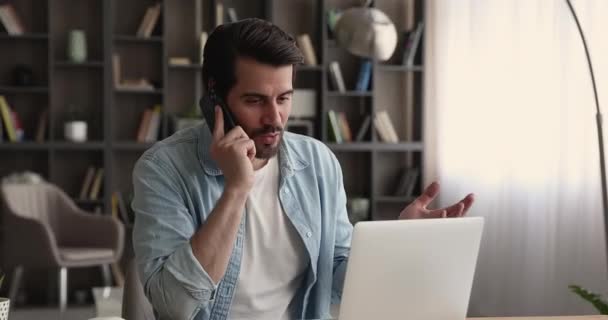 Geschäftsmann sitzt am Arbeitsplatz und telefoniert — Stockvideo