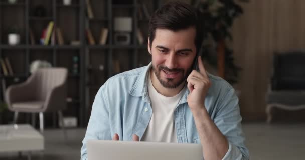 Hombre de negocios seguro sentado en el lugar de trabajo hablando por teléfono — Vídeos de Stock