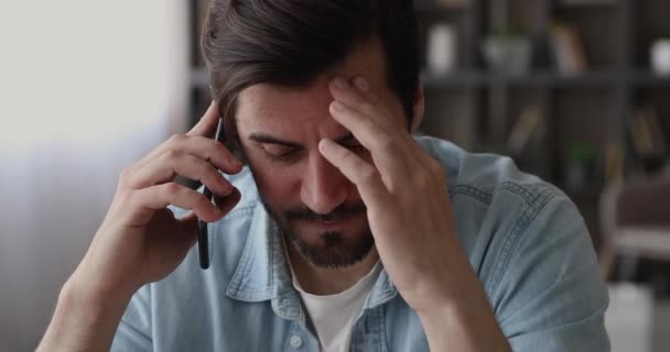 El hombre se siente molesto escuchando malas noticias por teléfono — Vídeos de Stock