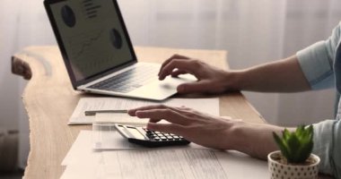 Hesap makinesi ve dizüstü bilgisayarın yakın plan görüntüsünü kullanarak çalışan muhasebeci.