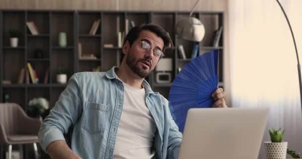 Geschäftsmann winkt Ventilator, der unter Hitze am Arbeitsplatz leidet — Stockvideo
