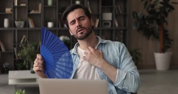 Geschäftsmann mit schwenkendem Ventilator leidet unter hohen Temperaturen am Arbeitsplatz — Stockvideo