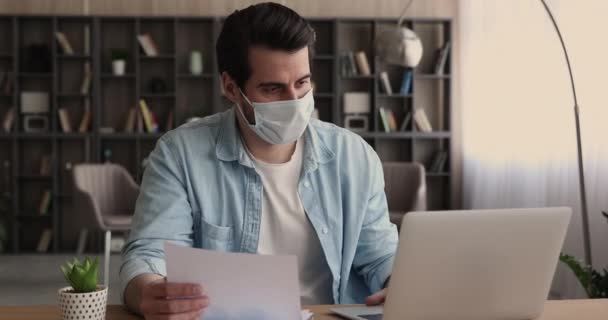 Employee in protective face mask hold document analyzing statistics data — Stock Video