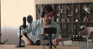 Gitarist bir gitar kaydı videosu çalıyor cep telefonu kullanıyor