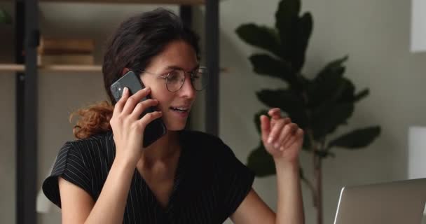 Geschäftsfrau führt angenehme Telefongespräche im Sitzen am Arbeitsplatz — Stockvideo