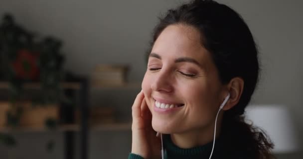 Błogosławiona młoda kobieta nosi słuchawki przewodowe słucha ulubionej melodii — Wideo stockowe