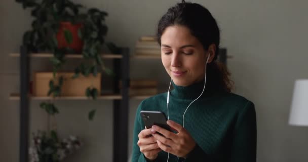 Mulher usar fones de ouvido com fio segurando smartphone escuta música favorita — Vídeo de Stock