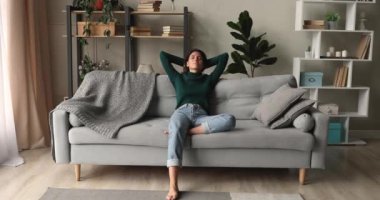 Kadın ellerini başının arkasına koyup kanepe yastıklarına yaslandı.