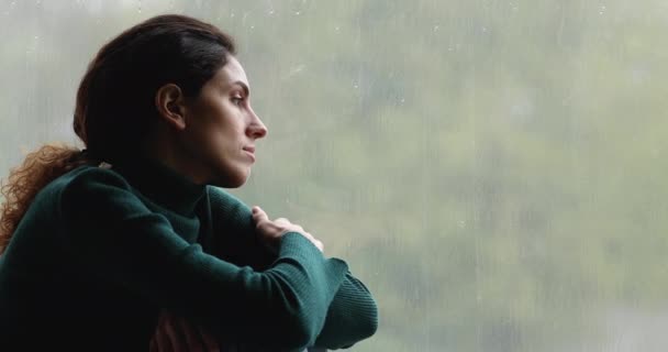 Mujer solitaria sentada en el interior del alféizar de la ventana en un clima sombrío — Vídeos de Stock