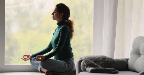 Donna seduta sul davanzale della finestra con gli occhi chiusi fare pratica di meditazione — Video Stock