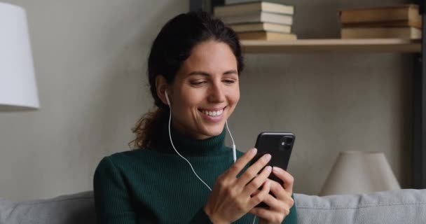 Mulher em fones de ouvido ouvir mensagens de áudio no smartphone — Vídeo de Stock