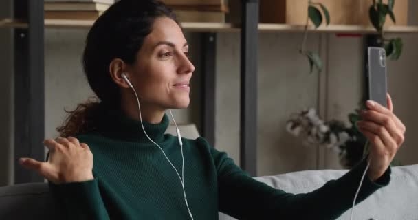 Kobieta nosić słuchawki przewodowe rozmowy z przyjacielem przez połączenie wideo — Wideo stockowe