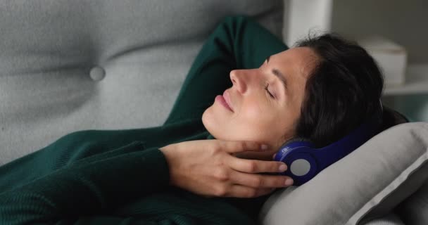 Ευχάριστη γυναίκα ακούει μουσική μέσω σύγχρονων ασύρματων ακουστικών — Αρχείο Βίντεο