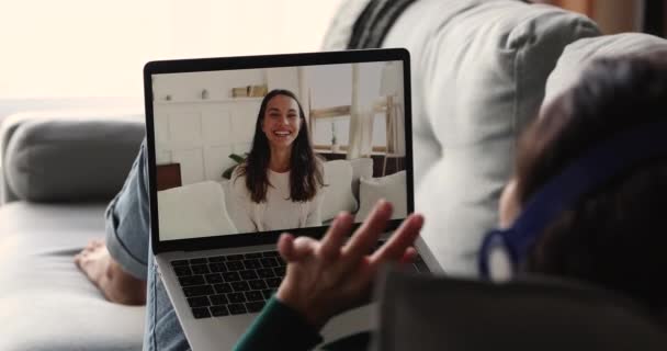 Жінка, що розслабляється в приміщенні, використовує ноутбук, розмовляючи з дівчиною за допомогою відеозапису — стокове відео