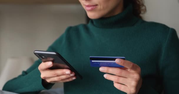 Perempuan memegang smartphone dan kartu kredit membuat pembelian aman online — Stok Video