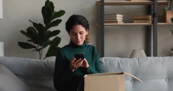 Kvinna kontrollera varor i paket använda mobilapplikation på telefon — Stockvideo