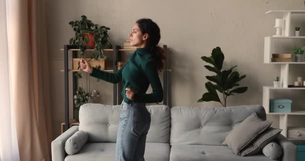 Vrouw luisteren muziek dansen plezier alleen in de woonkamer — Stockvideo