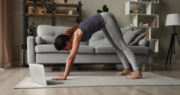 Žena používat notebook hodinky on-line cvičení trénink opakovat jógu asana — Stock video