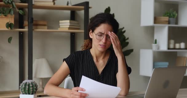 Αναστατωμένη γυναίκα που κάθεται στο γραφείο διαβάζει γράμμα με άσχημα νέα — Αρχείο Βίντεο