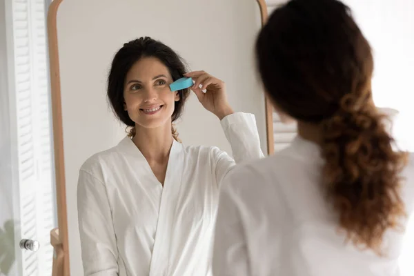 Szczęśliwa kobieta masaż twarz z peeling gąbka — Zdjęcie stockowe