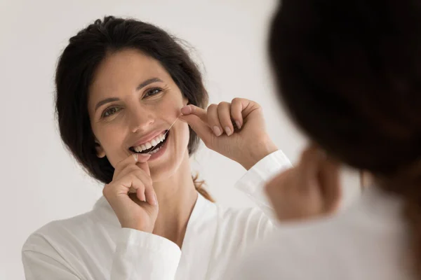 Smiling woman clean teeth with dental floss — Stock Photo, Image