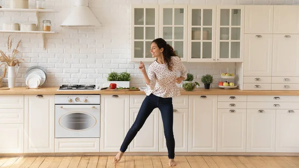 Щаслива жінка прокату насолоджується танцями на домашній кухні — стокове фото