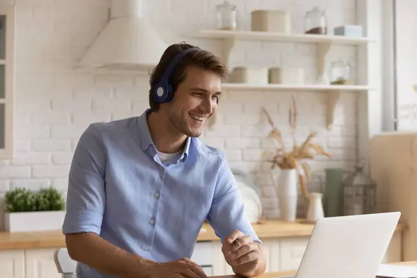 Glimlachende man in hoofdtelefoon kijken webinar op laptop — Stockfoto
