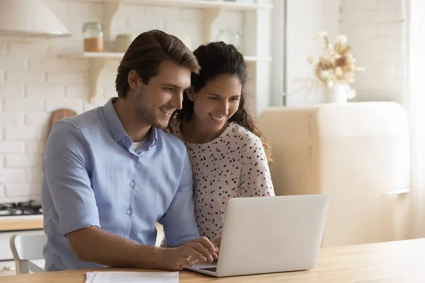 Счастливая кавказская пара использует ноутбук дома — стоковое фото