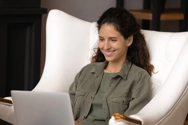 Mujer feliz relajarse en la silla con el ordenador portátil —  Fotos de Stock