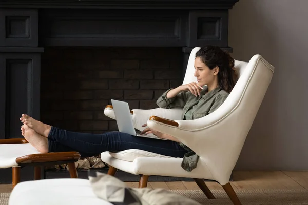 Feliz mulher milenar relaxar em casa trabalhando no laptop — Fotografia de Stock