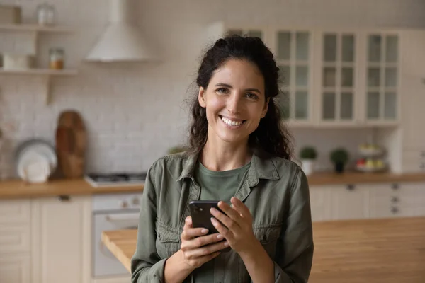 Retrato de la mujer sonriente usar el teléfono inteligente en casa — Foto de Stock