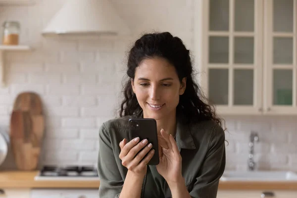 Szczęśliwa kobieta przeglądać internet na nowoczesny smartfon — Zdjęcie stockowe