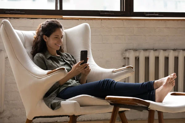 Boldog nő pihenni szék segítségével modern okostelefon — Stock Fotó