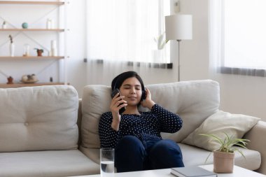 Rahatlamış genç Koreli Asyalı kulaklıkla müzik dinliyor.