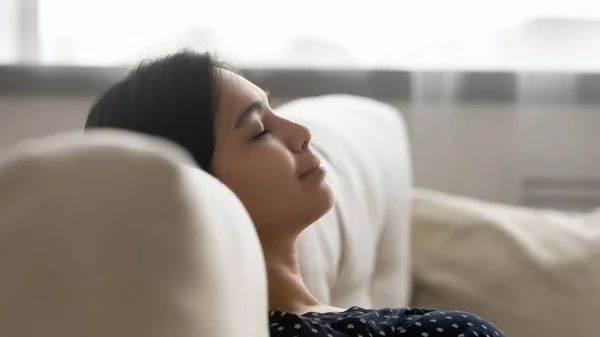 Happy serene millennial asian woman sleeping on sofa. — Stock Photo, Image