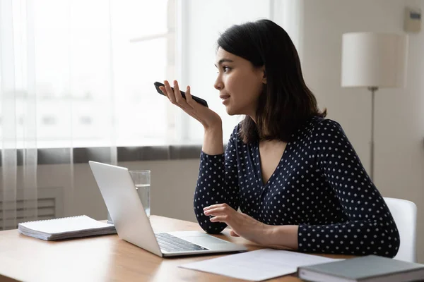 Concentrated young korean multiracial businesswoman recording audio message. — Stock Photo, Image