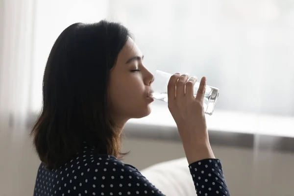 Молодая многонациональная азиатская корейская женщина пьет холодную дистиллированную воду. — стоковое фото